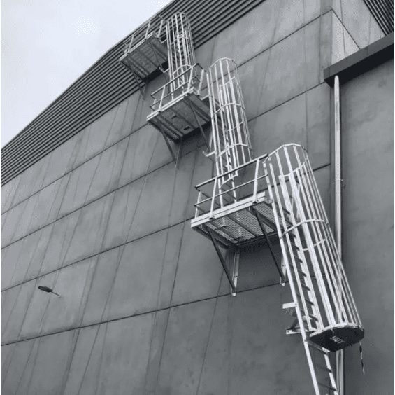 Ground level to roof top access prodided by tripple angled rung ladders with safety cages, 2 midway landing platforms and another at the roof top